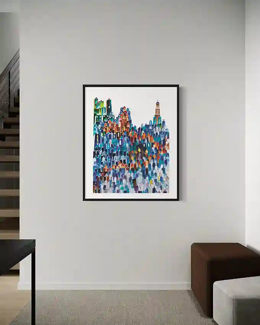 Colorful abstract cityscape art print in a black frame on a white wall. by Sudanese artist Yousif Ibrahim, in UAE