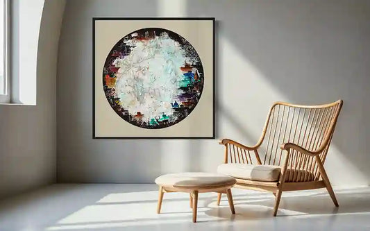 Modern interior with a wooden chair, small table, & art print "Circle 9" on a wall. by artist Yousif Ibrahim, in UAE