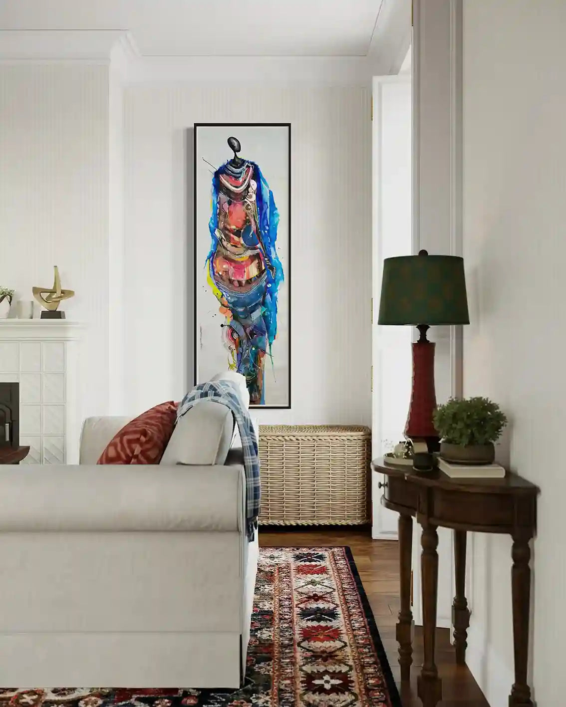 Grace by Mohamed Wraag in black frame on white wall above cream sofa, vertical Sudanese woman painting in blue with side table