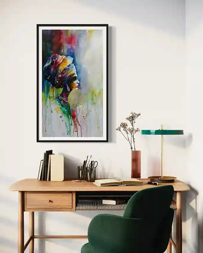 Colorful abstract framed art print by Galal Yousif of an African woman with a headdress on a wall above a desk. in UAE