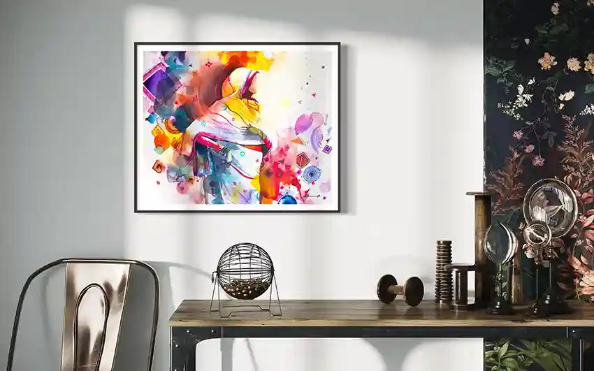 Colorful abstract Art print by artist Galal Yousif framed on a wall above a wooden desk with decorative items. UAE