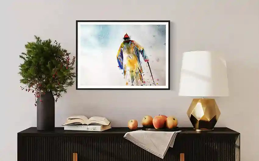 Framed art print by Sudanese artist Galal Yousif with old man on a wall above a console table with decorative items. in UAE.