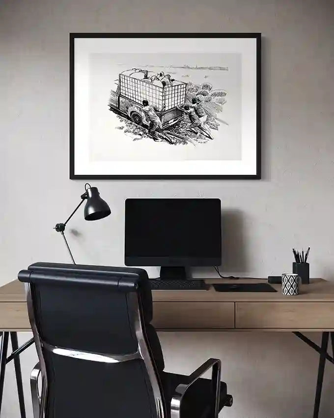 Modern home office with black desk chair, computer monitor, and framed "Stuck in the Mud" vintage art print on gray wall