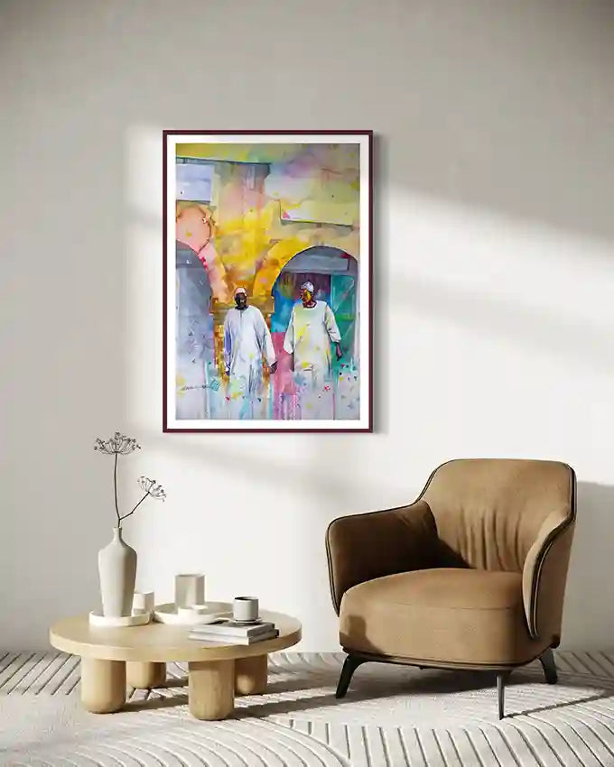 Modern living room with a beige armchair, round coffee table, and framed art print by Galal Yousif on the wall.