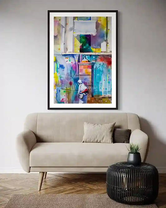 Colorful  framed abstract print of A Sudanese woman on wall above beige sofa with a black side table. Artist Galal Yousif