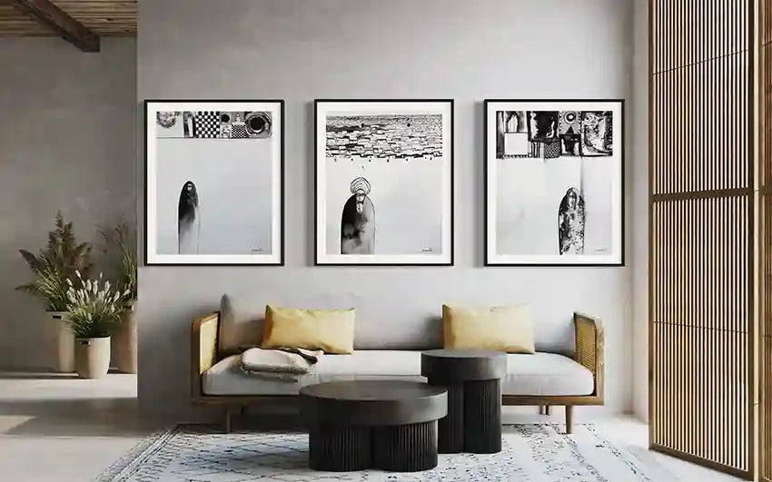 Three black and white art prints by Abushariaa Ahmed as gallery wall above modern sofa in contemporary living room