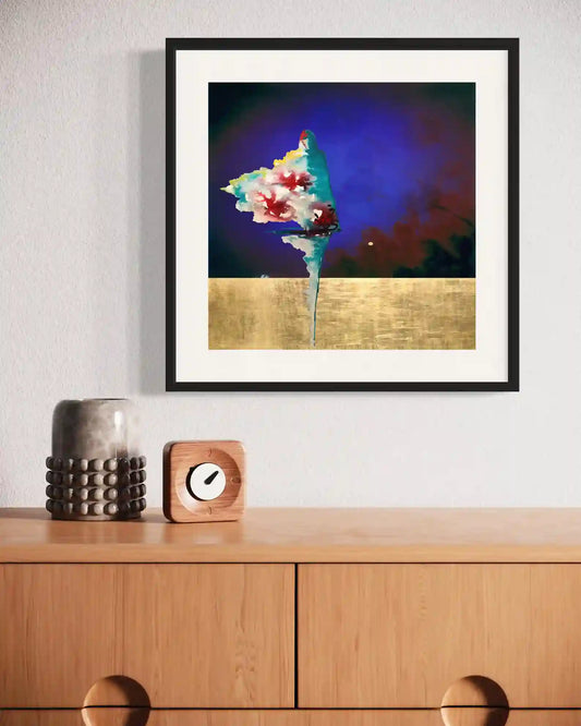Framed 'Bloom' digital art print displayed above wooden sideboard with decorative vase and clock in modern interior