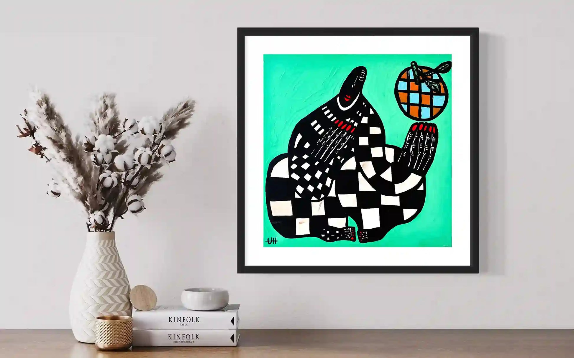 Blue Orange artwork by Usra Hamza in black frame on wall with dried flowers and Kinfolk books creating minimalist display