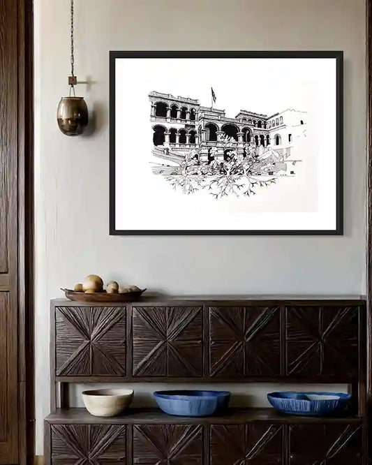 The Peoples Palace art print by Obada Gabir displayed in black frame on white wall above wooden sideboard in modern rustic interior