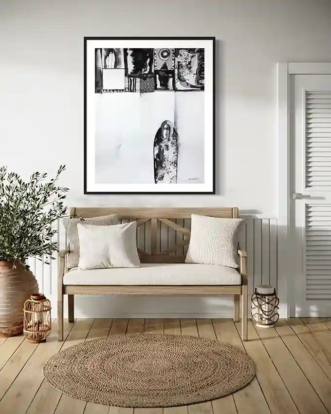 "Patterned Solitude" art print by Abushariaa Ahmed framed above wooden bench in modern coastal interior setting