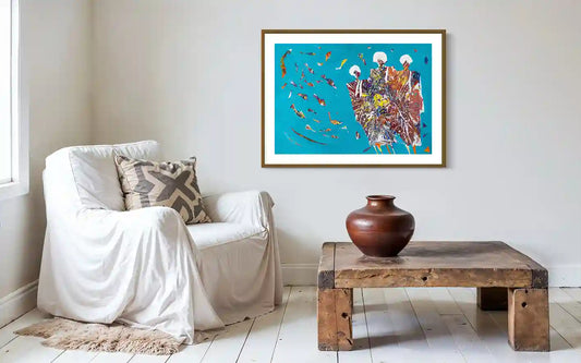 Sufi Sea 1 art print by Hani Khalil in gold frame on white wall above rustic wooden coffee table and white armchair
