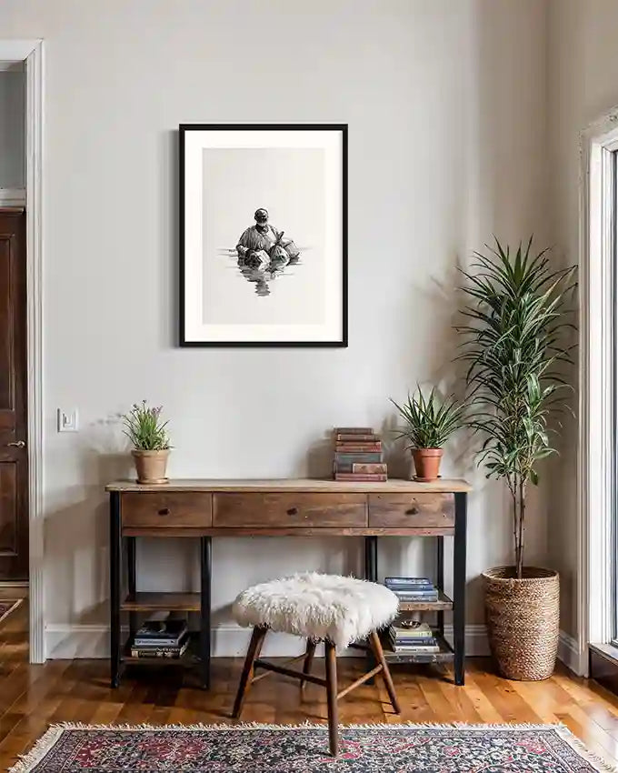 The Crossing by Obada Gabir framed black and white artwork displayed above wooden console table in warm cozy home interior