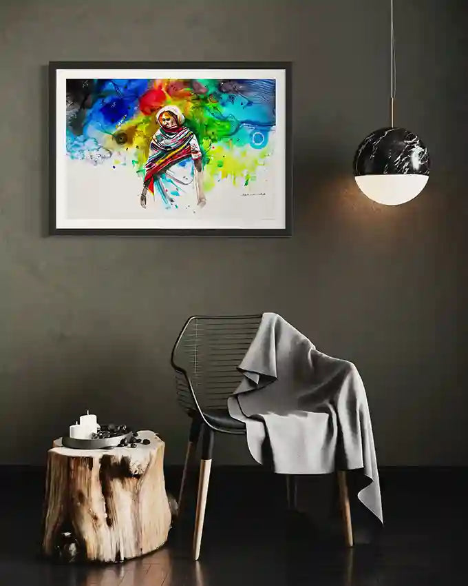 Framed colorful art print of a Sudanese woman on a wall above a chair with a gray blanket, by artist Galal Yousif, in UAE 