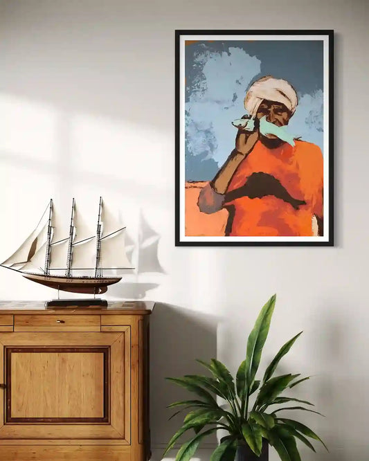 'Starring 2' by Bakri Moaz framed fisherman art print displayed above wooden cabinet with model ship and plant decor