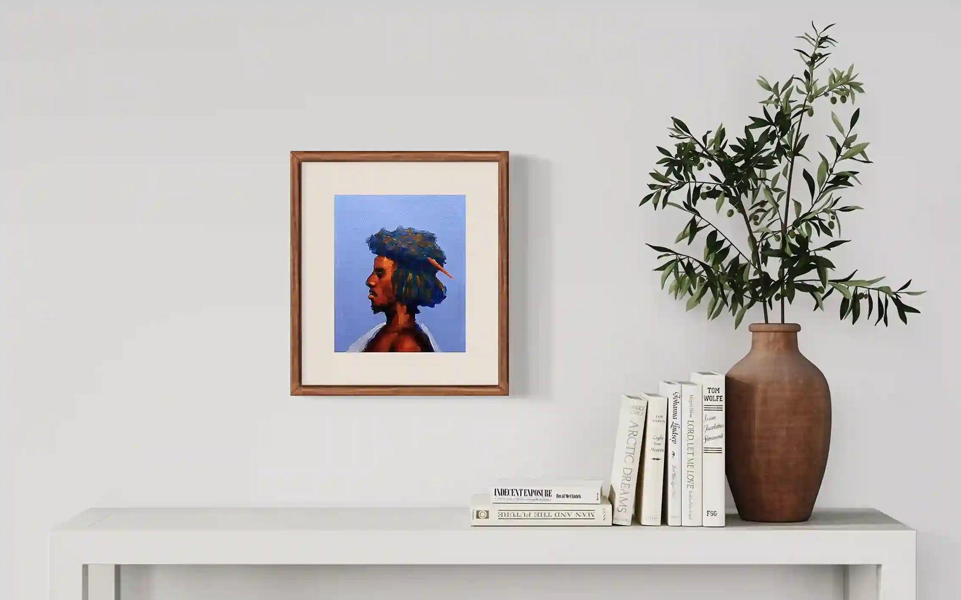 Beja 2 portrait by Osman Adam displayed in wooden frame on white shelf with books and plant home decor mockup
