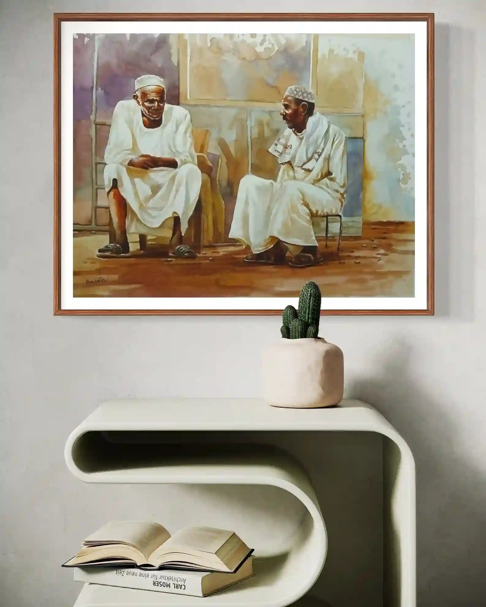 Between Old Friends framed watercolor by Hussein Merghani above white console with cactus plant home decor mockup