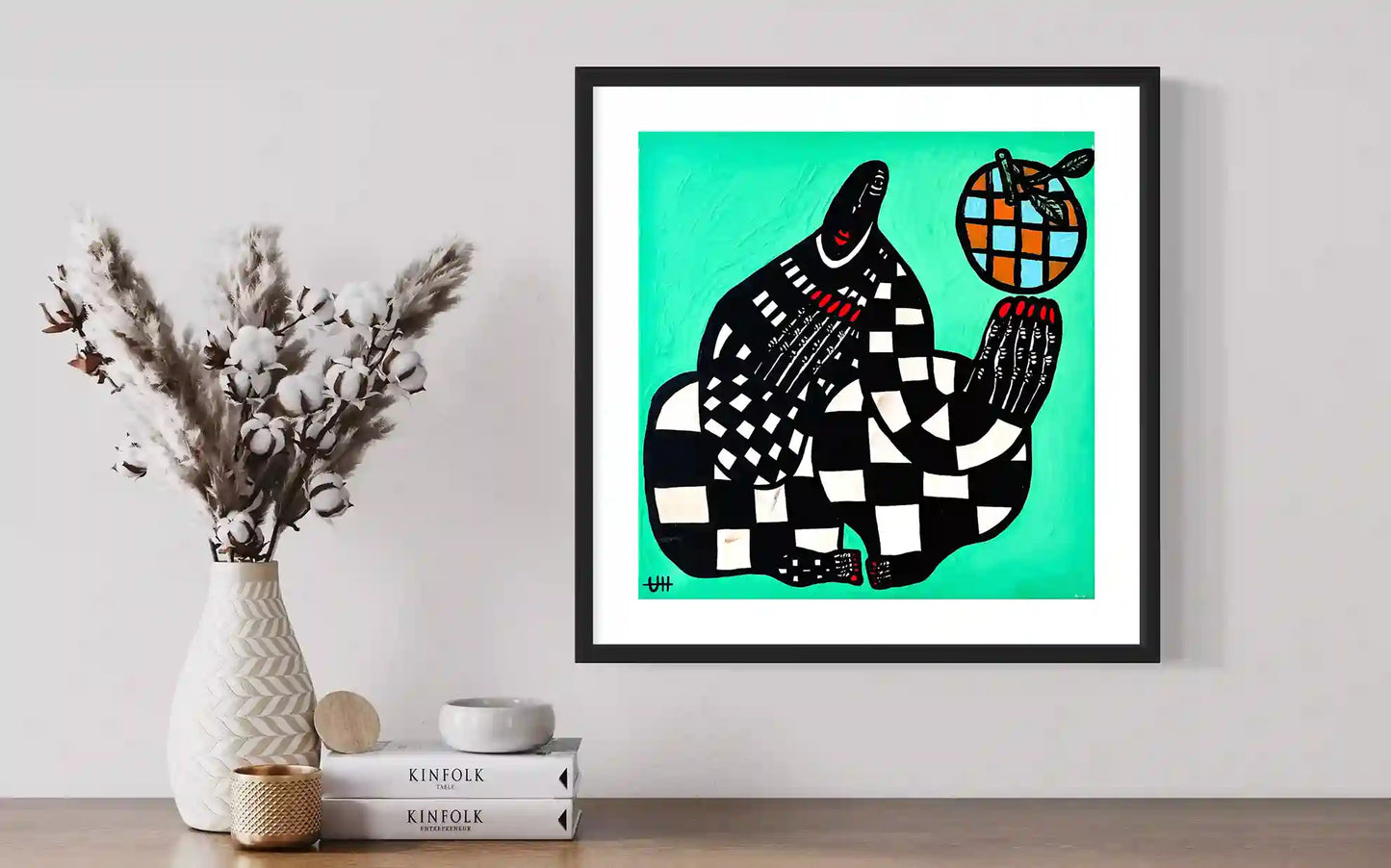 Blue Orange artwork by Usra Hamza in black frame on wall with dried flowers and Kinfolk books creating minimalist display