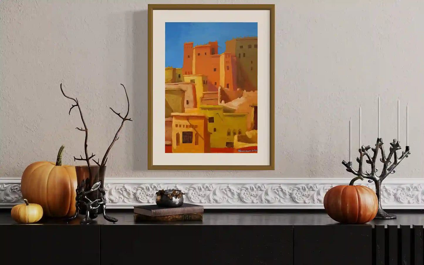Golden Medina original painting by Osman Adam displayed on wall with autumn decor showing African architecture