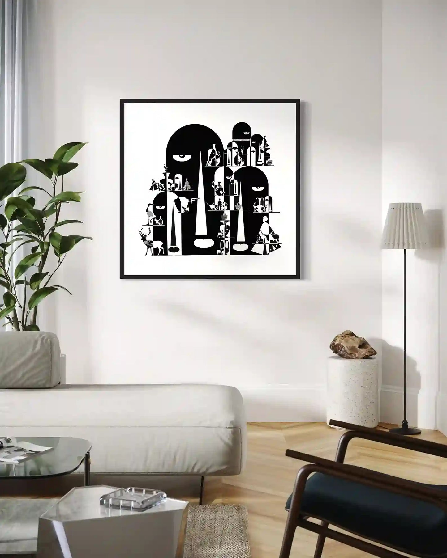 Tombs black and white art print by Gungalito framed in black on white wall in minimalist living room with sofa and chair