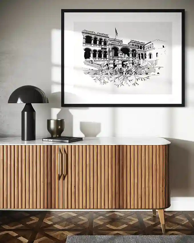 The Peoples Palace large art print by Obada Gabir displayed in black frame on white wall above wooden sideboard in modern rustic interior