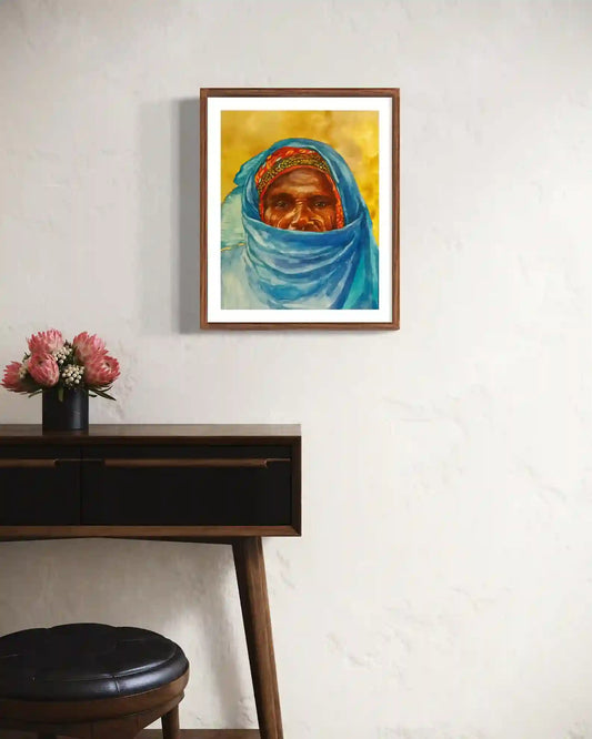 Veiled Grace watercolor by Hussein Merghani framed mockup in modern interior with wooden desk and pink flowers